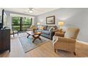 Relaxing living room featuring a cozy couch, natural light from the glass sliding door, and stylish decor at 45 Pinehurst Ln. # 2G, Pawleys Island, SC 29585