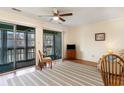 Inviting living room with balcony access, neutral walls, and a TV atop a wooden dresser at 500 Fairway Village Dr. # 5D, Myrtle Beach, SC 29588