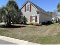 A lovely side yard, edged with well-maintained landscaping, featuring trimmed bushes and decorative brick at 59 Willowbend Dr., Murrells Inlet, SC 29576
