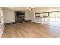 Open concept living area with fireplace, TV, hardwood floors, and view into the kitchen at 7638 Highway 905, Longs, SC 29568