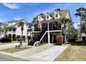 Charming two-story home with a fountain, double garages, and a covered porch adorned with American flags at 817 Falkirk St., Myrtle Beach, SC 29579
