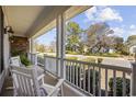 Relaxing front porch with white rocking chairs overlooking the peaceful street and landscaping at 820 Morrall Dr., North Myrtle Beach, SC 29582