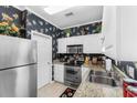 A modern kitchen with stainless steel appliances, granite counters, and white cabinets provides ample storage at 9764 Leyland Dr. # 9764 - 5, Myrtle Beach, SC 29572