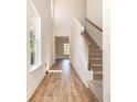 Bright hallway featuring hardwood floors, high ceilings, and a staircase with carpeted steps at 1219 Inlet View Dr., North Myrtle Beach, SC 29582