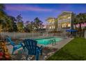 Relaxing poolside view showcasing a private pool, lush landscaping and stylish patio furniture at 213 S Myrtle Dr., Surfside Beach, SC 29575