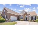 Beautiful brick home with a manicured lawn, a two-car garage, and an arched front entrance at 324 Highfield Loop, Myrtle Beach, SC 29579