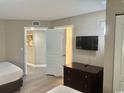 Bright bedroom with hardwood flooring, TV, and dresser at 3500 N Ocean Blvd. # 1203, North Myrtle Beach, SC 29582