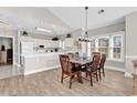 A dining area with wooden table and chairs, open to the kitchen, with natural light from the windows at 4827 Orchid Way # 301, Myrtle Beach, SC 29577