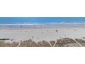 Expansive beach view with a mix of sand dunes, beachgoers, and the ocean at 501 S Ocean Blvd. # 1002, North Myrtle Beach, SC 29582