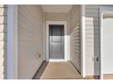 Front door is gray with a covered walkway and beige siding at 156 Joyce Dr, Longs, SC 29568