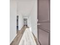 Bright hallway with wood-look flooring and white walls leads to bedrooms and living spaces at 156 Joyce Dr, Longs, SC 29568