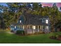 Charming two-story blue home featuring a lovely front porch and well-manicured landscaping at 160 Shipmaster Ave., Pawleys Island, SC 29585