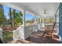 Inviting front porch with rocking chairs, white railings, and scenic views of the lush neighborhood at 160 Shipmaster Ave., Pawleys Island, SC 29585