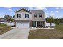 Charming two-story home with a well-manicured lawn, brick accents, and a cozy front porch at 206 Math Place, Longs, SC 29568