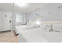 Bright bedroom featuring two beds with white bedding, tile flooring, and beach themed decorations at 2001 S Ocean Blvd. # 720, Myrtle Beach, SC 29577