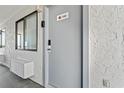 Condo entrance featuring a grey door, a window, and light-colored stucco walls at 2001 S Ocean Blvd. # 720, Myrtle Beach, SC 29577