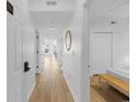 Bright hallway with hardwood floors featuring a mirror, multiple doors and beach views at the end of the hall at 3401 Ocean Blvd. N # 103, North Myrtle Beach, SC 29582