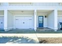 Exterior view of a well-maintained townhome, showcasing a garage, front door, and tidy landscaping for a welcoming appeal at 4850 Cantor Ct. # 202, North Myrtle Beach, SC 29582