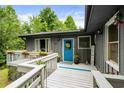 Inviting front porch with gray siding, a bright blue door, and seasonal decorations at 532 Medcalf Dr. Sw, Sunset Beach, NC 28468