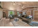 Comfortable living room with wood-paneled walls and ceiling, and a large sectional sofa at 532 Medcalf Dr. Sw, Sunset Beach, NC 28468
