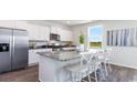 Bright kitchen with white cabinets, stainless steel appliances, granite countertops, and a large island with seating at 555 Firouz Dr, Longs, SC 29568