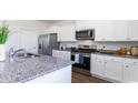 Well-equipped kitchen featuring white cabinets, stainless steel appliances, granite countertops, and a kitchen island at 555 Firouz Dr, Longs, SC 29568