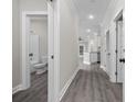 Hallway with gray wood-look flooring, white doors, and leading to the kitchen and living area at 627 Bonaventure Dr. # 203, Myrtle Beach, SC 29577