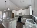 Modern kitchen featuring white cabinets, granite countertops, stainless steel appliances, and a center island at 1274 Pinetucky Dr., Galivants Ferry, SC 29544