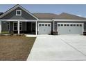 Charming home exterior features a two-car garage, gray siding, and a well-manicured lawn at 242 River Edge Dr., Myrtle Beach, SC 29588
