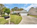 Charming home featuring a lush lawn, mature trees, and a convenient driveway leading to the attached garage at 1292 Merion Ct., Murrells Inlet, SC 29576