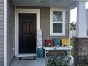 Inviting front porch featuring decorative pillows, 'Farmhouse Blessings' sign, and stylish decor at 187 S Reindeer Rd., Surfside Beach, SC 29575