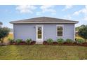 Rear exterior showcasing blue siding, a simple yard, and a door for convenient outdoor access at 204 Jeff Waters Circle, Longs, SC 29568