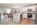 Open-concept kitchen with stainless steel appliances, white cabinets, and a view of the living area at 204 Jeff Waters Circle, Longs, SC 29568