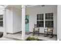 Inviting front porch with rocking chairs, a wreath, and a stylish black-and-white doormat at 2827 Allen Dew Rd., Conway, SC 29527
