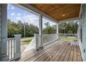Inviting covered porch with wood flooring and ceiling, featuring a scenic neighborhood view at 3851 Journeys End Rd., Murrells Inlet, SC 29576