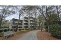 Condo complex nestled among trees with a sidewalk leading to the units at 415 Ocean Creek Dr. # 2443, Myrtle Beach, SC 29572