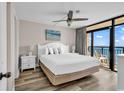 Bright main bedroom boasts a white bed set and balcony access with an ocean view at 4800 S Ocean Blvd. # 1103, North Myrtle Beach, SC 29582