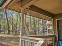 A lovely porch view showcasing a 'Beach' hanging decor, natural landscaping, and surrounding trees at 400 Melrose Pl. # 14-A, Myrtle Beach, SC 29572