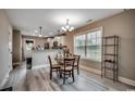 Cozy dining area with wood floors, pendant lights, and a view of the modern kitchen at 1390 Highway 129, Galivants Ferry, SC 29544