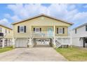 Inviting raised beach house featuring a light yellow exterior and a welcoming, covered entry at 308 36Th Ave. N, North Myrtle Beach, SC 29582