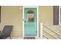 The turquoise front door has decorative glass and a brushed silver handle, complete with seashell decor at 308 36Th Ave. N, North Myrtle Beach, SC 29582