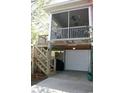 Back exterior view of home showing screened in porch with stairs leading to ground level garage and storage at 3904 Birchwood St., North Myrtle Beach, SC 29582