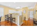 Cozy kitchen features white cabinets, breakfast bar, and hardwood floors at 601 Hillside Dr. N # 2305, North Myrtle Beach, SC 29582