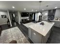 Open-concept living space with hardwood floors, with a modern kitchen featuring a large central island with bar stool seating at 710 62Nd Ave. N, Myrtle Beach, SC 29572