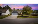 Charming single-story home featuring a manicured lawn, mature tree, and a two-car garage at 90 Carolina Crossing Blvd., Little River, SC 29566