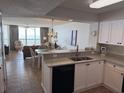 Open-concept kitchen featuring white cabinets, marble countertops, and an ocean view at 102 N Ocean Blvd. # 903, North Myrtle Beach, SC 29582