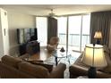 Comfortable living room with a ceiling fan and large glass doors to the balcony with an ocean view at 102 N Ocean Blvd. # 903, North Myrtle Beach, SC 29582