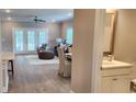 Open-concept living room featuring hardwood floors, neutral paint, lots of light, and half bath at 1415 Gooseneck Place # 202, Murrells Inlet, SC 29576