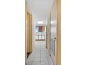 Hallway leading to a kitchen with white cabinetry, appliances, and a tiled floor at 1604 N Ocean Blvd. # 904, Myrtle Beach, SC 29577