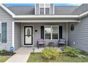 Cozy front porch featuring stylish seating, a decorative door, and well-maintained landscaping at 1794 Graham Rd., Aynor, SC 29544